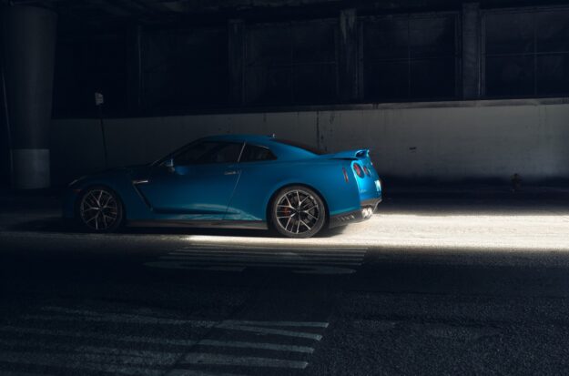 Rendered blue race car in shadows.
