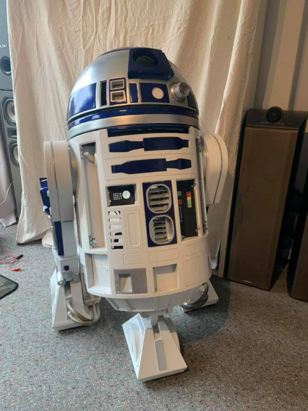 A life-sized 3D printed replica of Star Wars’ R2-D2, a service robot, stands tall and fully assembled with a white body, a silver domed head, and dark blue accents.