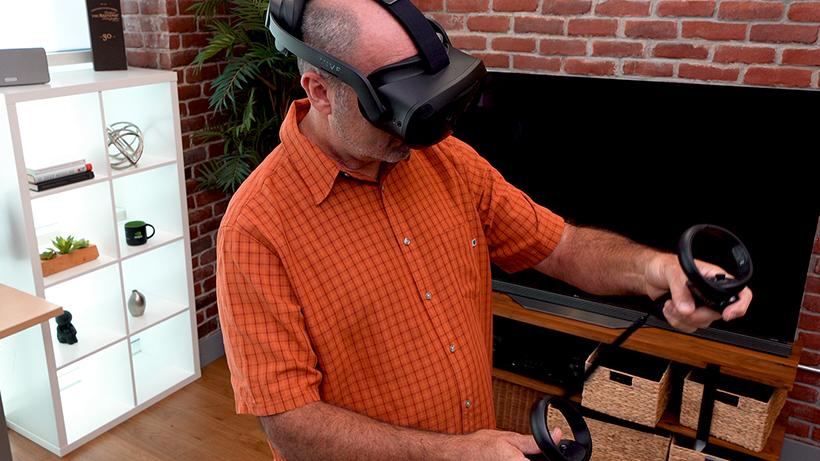 Man wearing an HTC VIVE VR headset and using controllers.