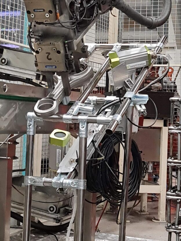 A robot picks up the rod for three cameras mounted left, right, and bottom.