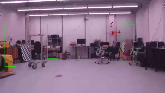 Indoor room with doors and chairs, desks, chessboard and cardboard boxes showing object detection model’s predictions in green bounding boxes