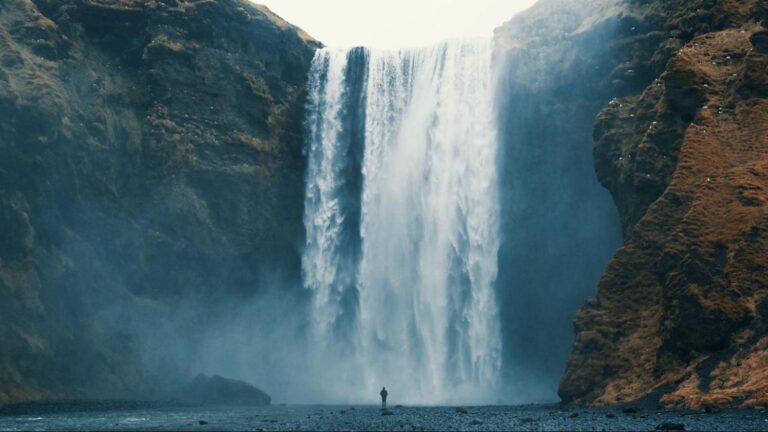 Person standing in front of waterfall