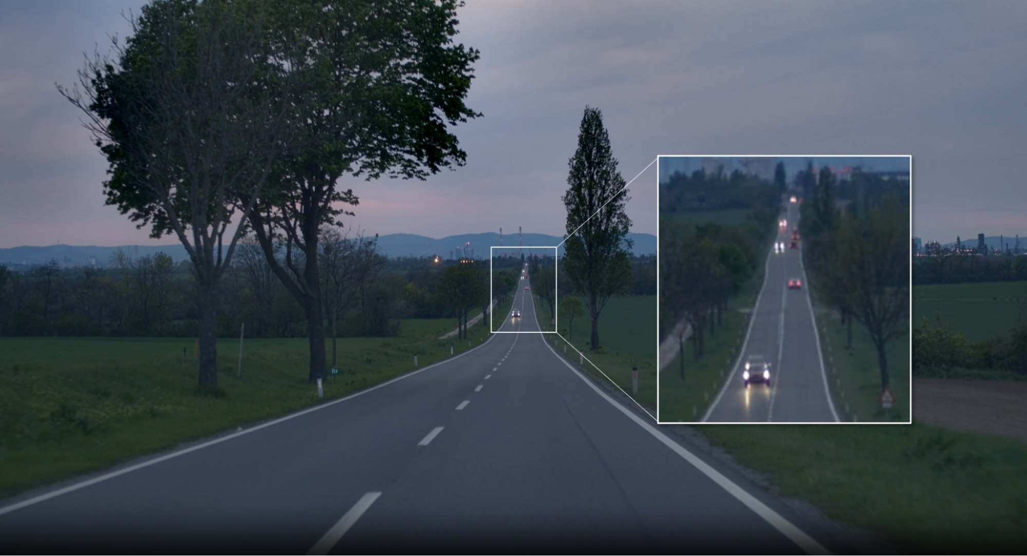 Camera frame showing a highway scene, with an insert showing long-distance vehicles at lower resolution.
