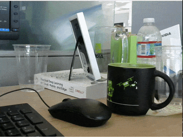 Handheld camera video footage showing objects on a desk with a computer mouse highlighted.